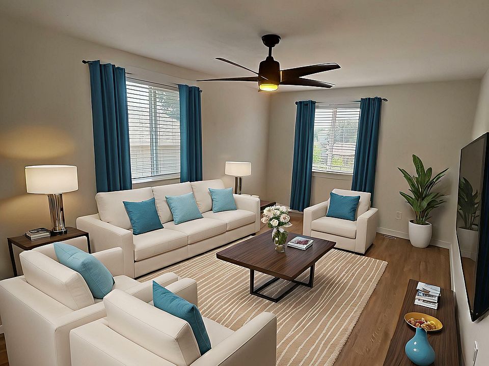 Inviting living room with modern white sofas, vibrant blue accents, and elegant wooden furniture, perfect for relaxing and entertaining.