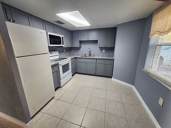 Kitchen features granite counters, fridge, microwave, and stove/oven