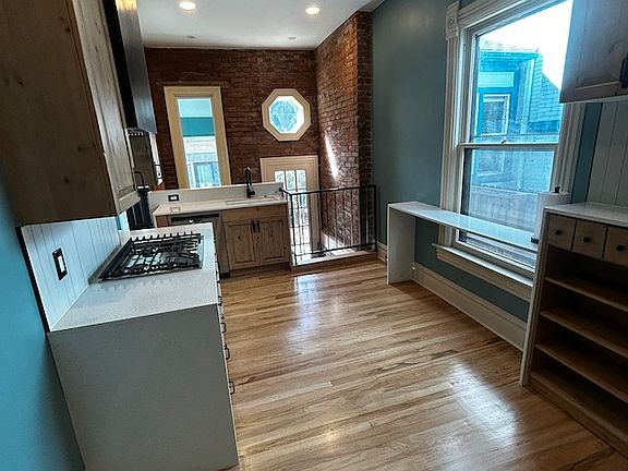 Kitchen with west wall exposed brick and one year old appliances