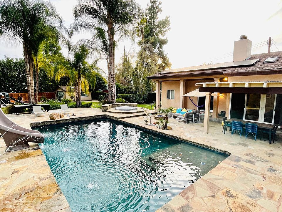 Pebble pool with baja bench perfect for little ones and lounging. Waterslide and fountains for extra fun. Covered dining area and outdoor lounge furniture. Mesh safety pool gate not pictured here but included with lease.