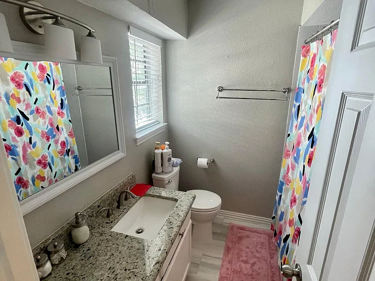 large, light filled full bathroom with tub/shower and a huge set of floor to ceiling cabinets behind the door for additional storage!