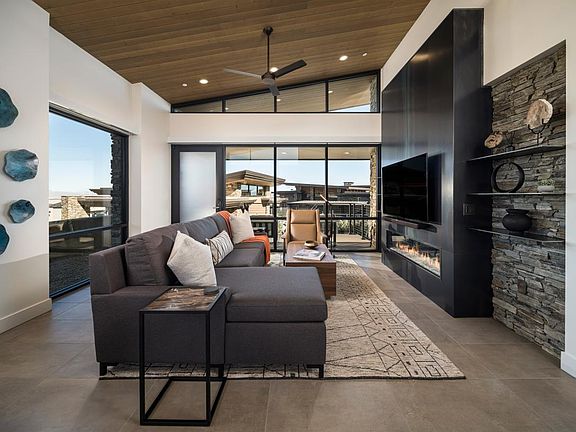 Open great room with fireplace, vaulted ceilings, and multi-slide patio door