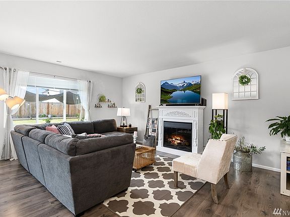Spacious family room with added white electric fireplace that stays with the home.