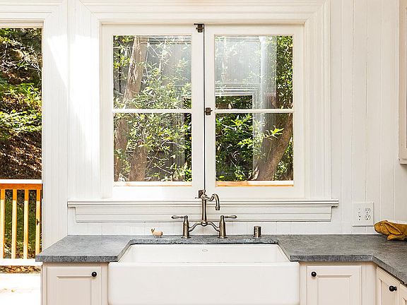 Custom kitchen lighting with forest views from window.