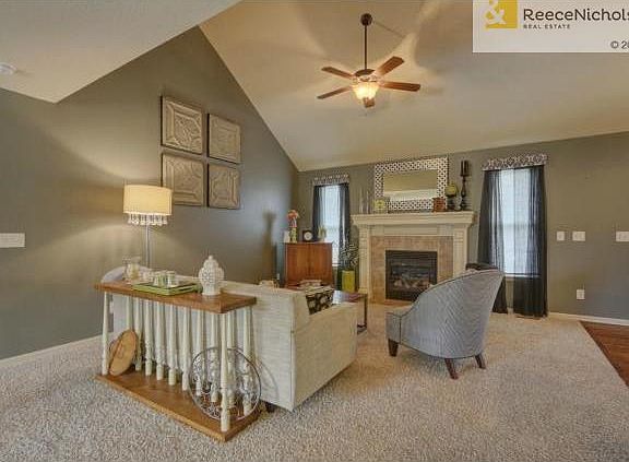 Living room has fireplace and vaulted ceiling.