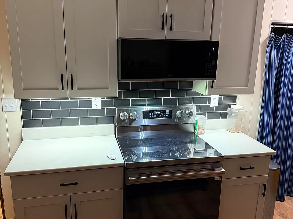 Kitchen with quartz countertops, black subway tile backsplash and under cabinet lighting with remote control