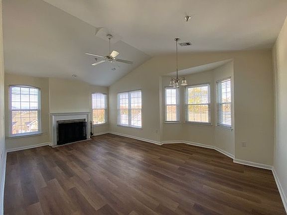 Living room with wood burning fireplace and dining area with bay window. Updated insulated double hung windows throughout.
