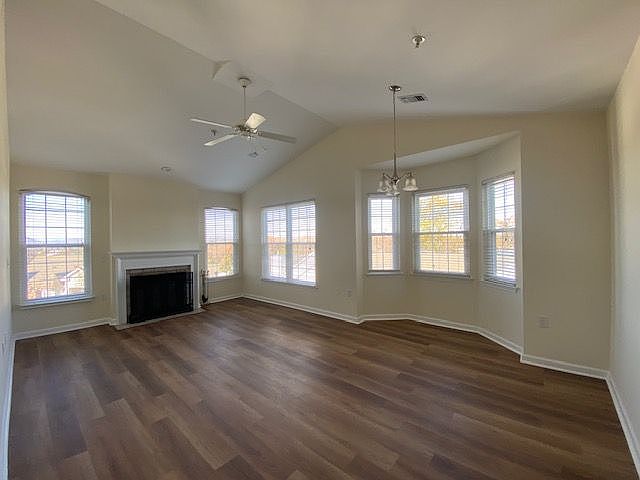 Living room with wood burning fireplace and dining area with bay window. Updated insulated double hung windows throughout.
