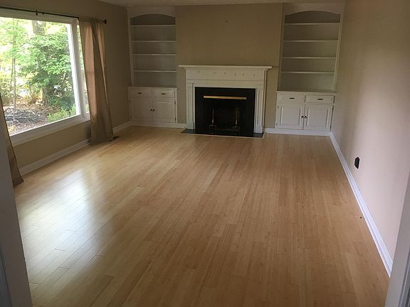 Living room with a wood burning fireplace and hardwood floor