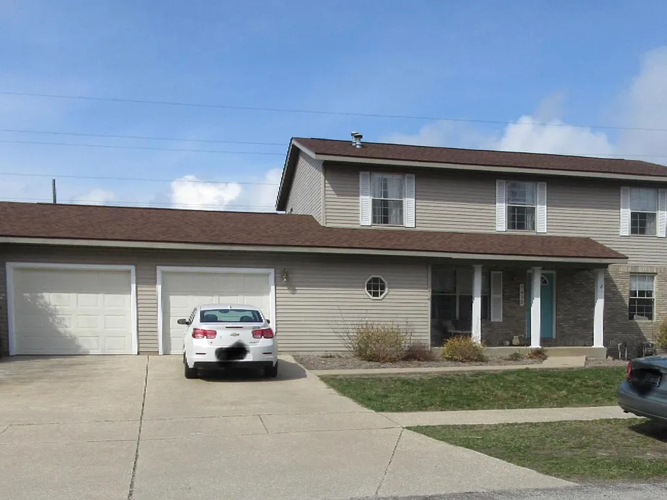 View of the duplex from the front of the building. This unit is on the second floor and contains the left side of the garage as well.