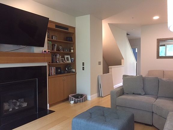 Living room has a fireplace and built in shelves and storage