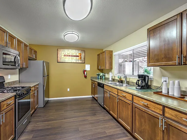 Resident kitchen with stove, microwave, refrigerator, dishwasher, and coffee machine.