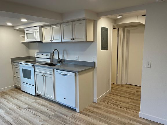 Kitchen with hallway to bathroom (open door on the left in the hallway). The closed door is a locked entry to the owner's area of the house (inaccessible from the apartment).