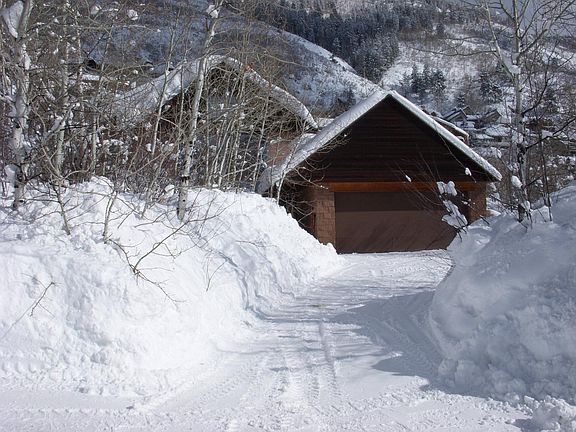 Here is a street view of the house peaking out from behind the garage on a snowy winter day.