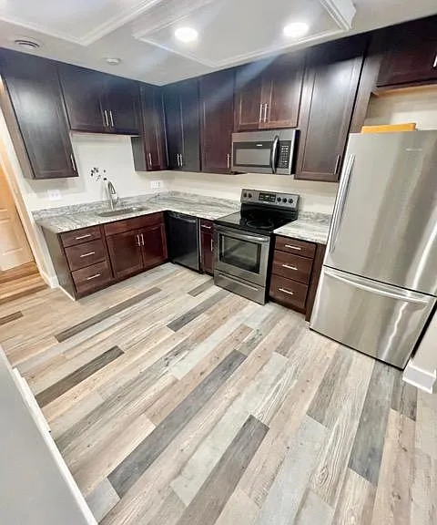 Kitchen, open concept to living room, hallway connects to laundry & storage.
