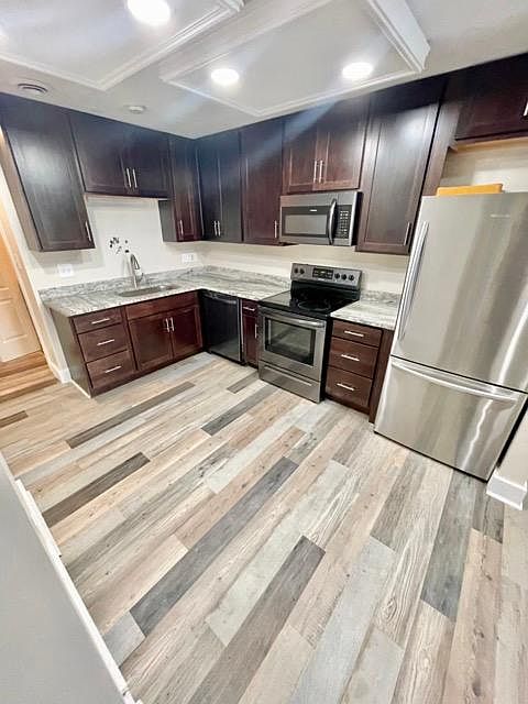 Kitchen, open concept to living room, hallway connects to laundry & storage.