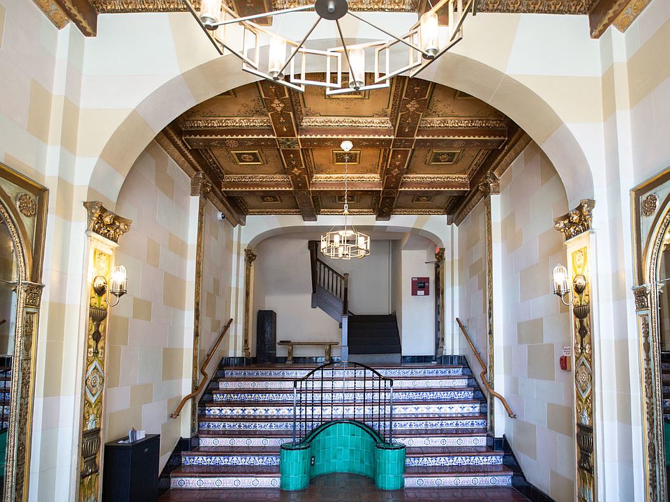 Grand hallway with a high ceiling, a chandelier, and a staircase