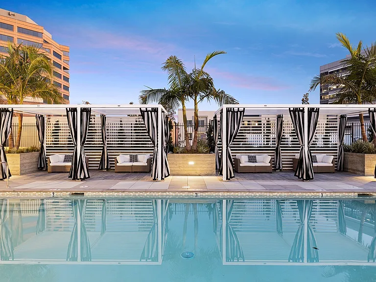 Lounge in style_striped cabanas and palm-lined views await.