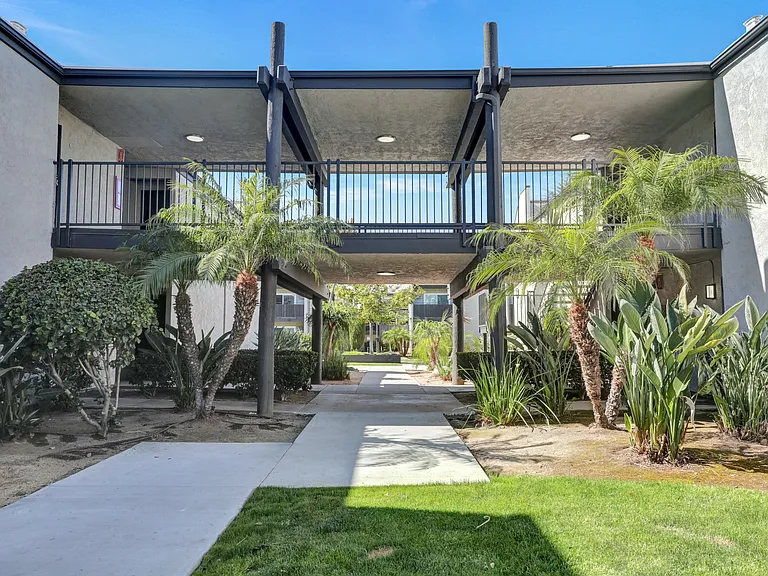 A modern building with a balcony and a walkway leading to it.