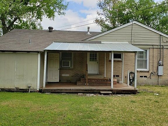 Back of the house with covered porch and utility room.