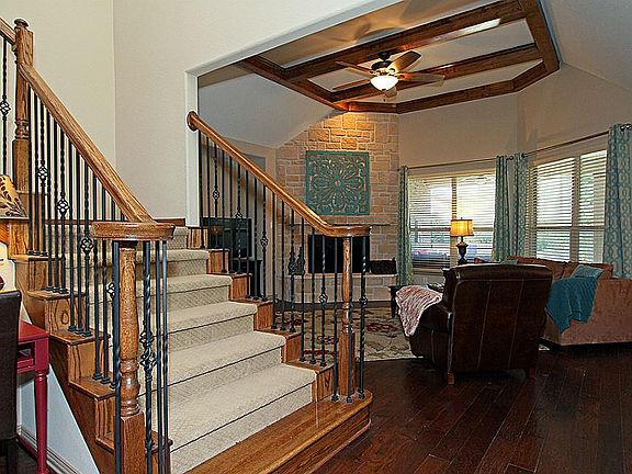 Walnut stained grand staircase with upgraded bottom all wood floors steps and upgraded wood beams throughout the living room.