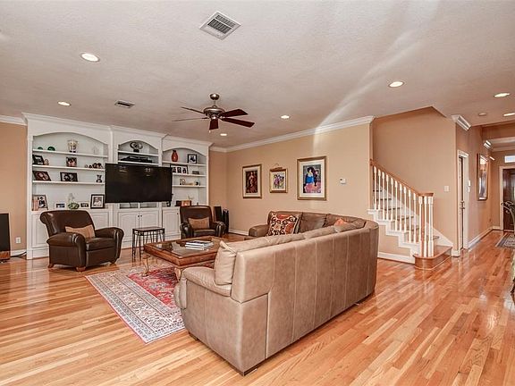 Large Great Room features Wood Flooring, a Gas Fireplace & Custom Built-ins
