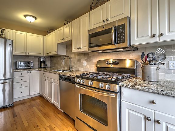 UPDATED EAT-IN KITCHEN WITH TILED BACKSPLASH, GRANITE COUNTERTOPS AND SS APPLICANCES. GAS STOVE.
