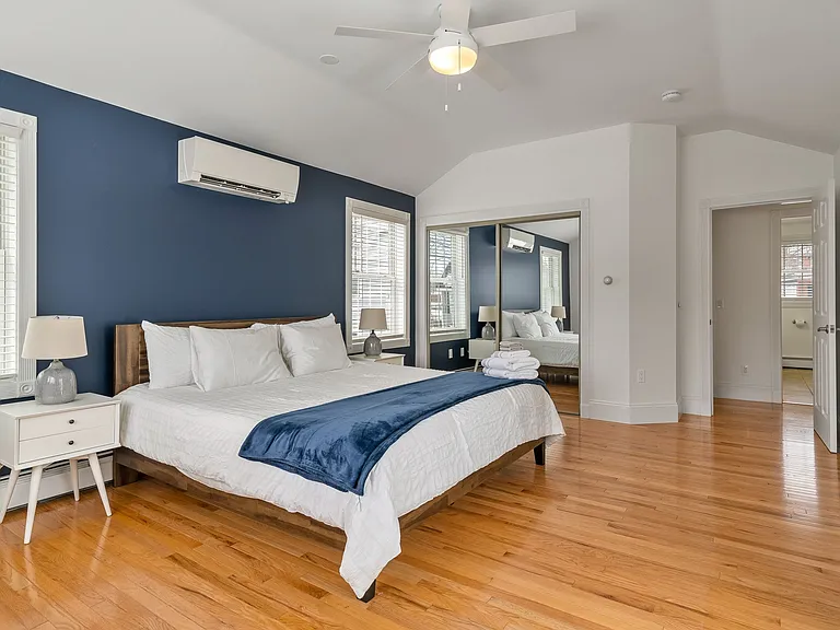 Bedroom, King Size Bed, Mini-Split AC, Natural Light, Large Windows, Modern Lighting, Hardwood Floors.