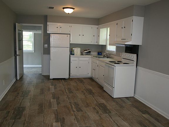 Kitchen/dining combination with stove and refrigerator furnished.