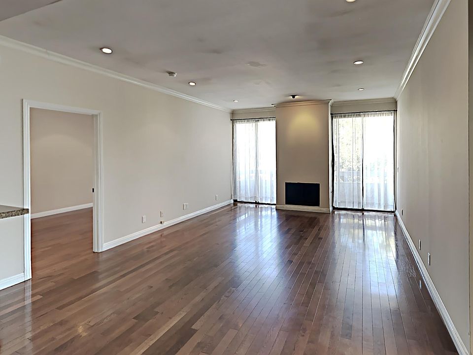 Living room with fireplace and tree view from a balcony
