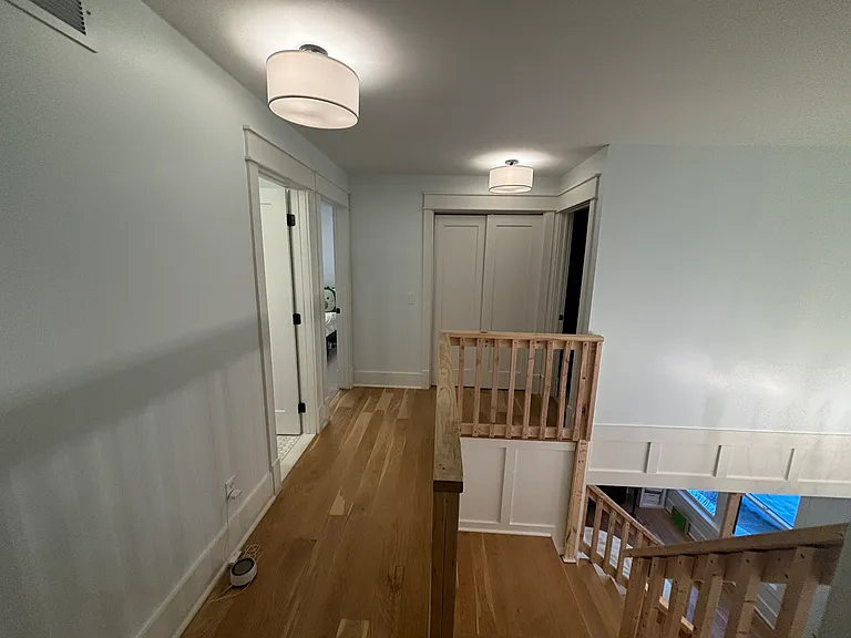Upper floor. Doors to bathroom and 2 bedrooms at end of hallway.