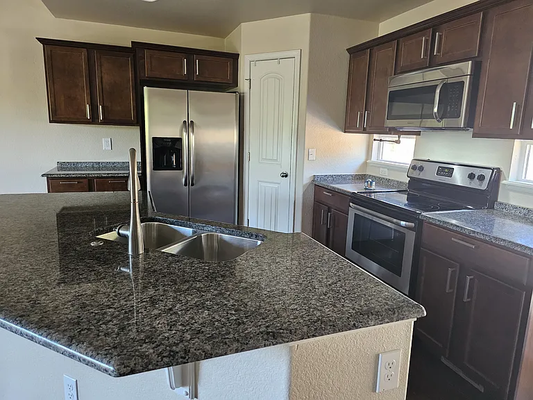 Granite counters, stainless kitchen appliances and spacious pantry storage