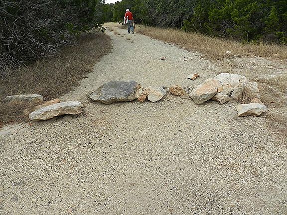  The street is currently blocked by rocks, but it is only a few steps to the lot.