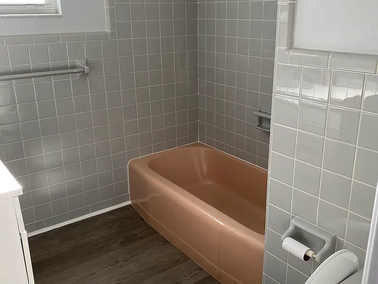 Main bathroom with tub and large vanity.