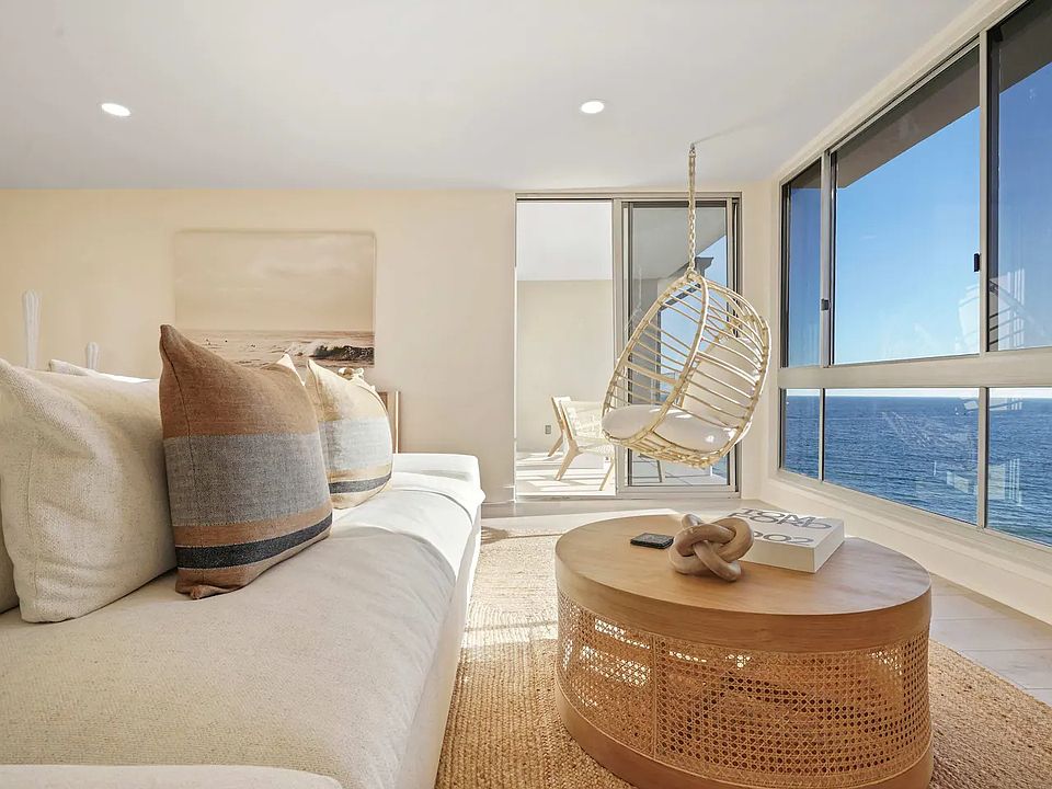 Spacious living room with plush seating, bathed in natural light and ocean views.