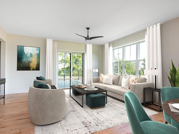Modern living room with neutral walls, a beige sofa, blue chairs, a wooden coffee table, and large w
