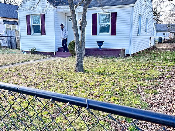 Front of house with a black chain fence. The house contains a floored attic with pull down access.
