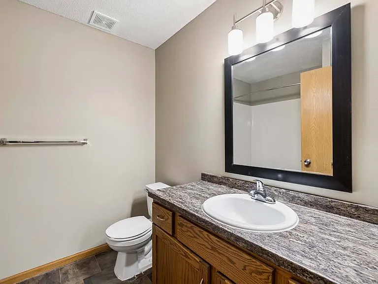 Warm wood cabinetry, a spacious vanity, and updated finishes create a bathroom that blends everyday comfort with timeless style.