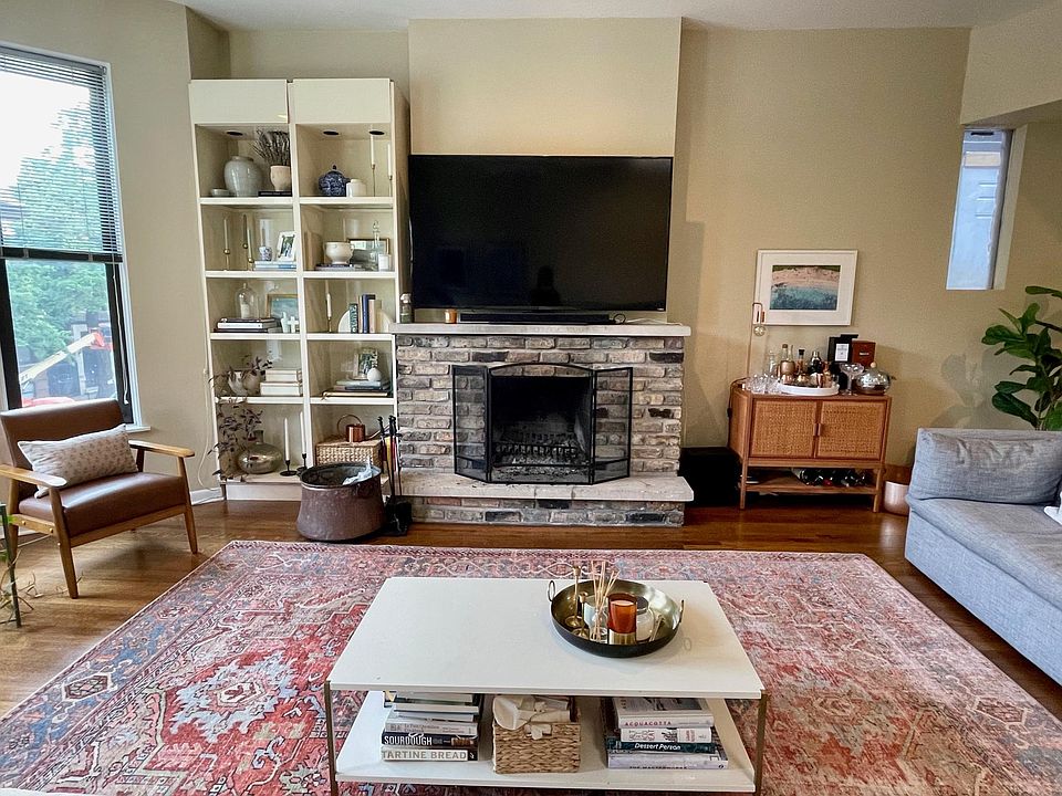 Living room with wood burning fireplace and built-in bookshelves
