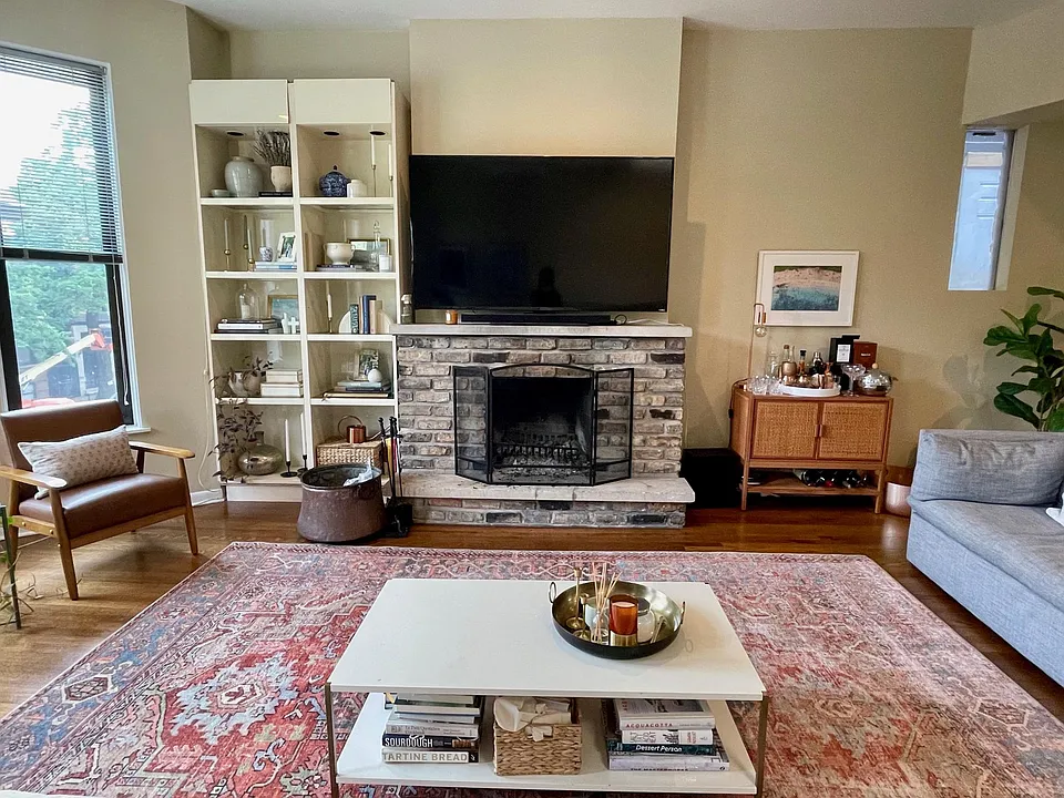 Living room with wood burning fireplace and built-in bookshelves