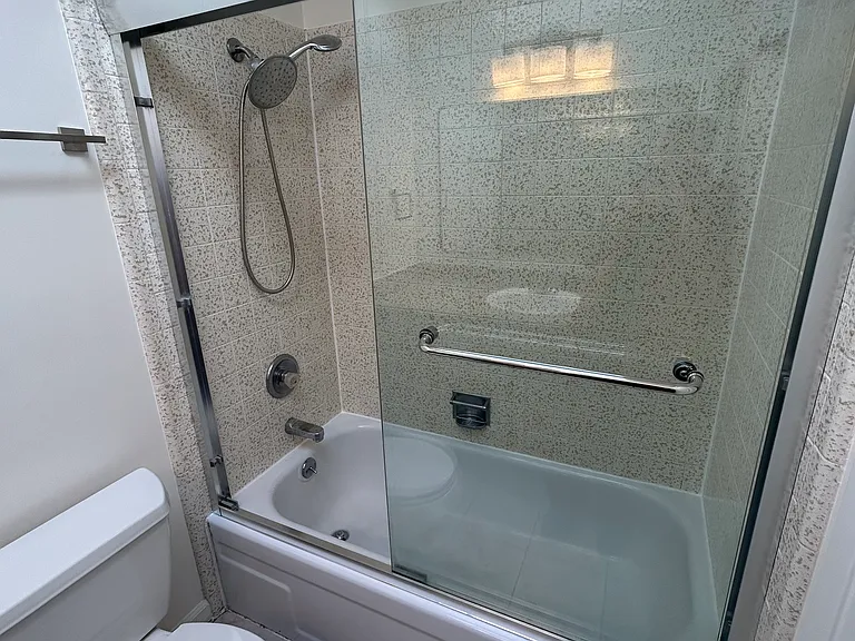 This bright bathroom with a skylight has a tub /shower.