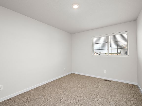 The master bedroom is spacious with a large window.