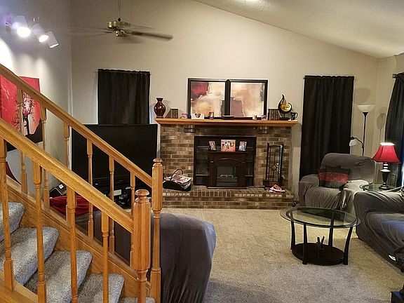 Living room, stairs to upper level Master and second Bedrooms, viewed from Dining Room. 12' vaulted ceiling. Wood-burning fireplace.