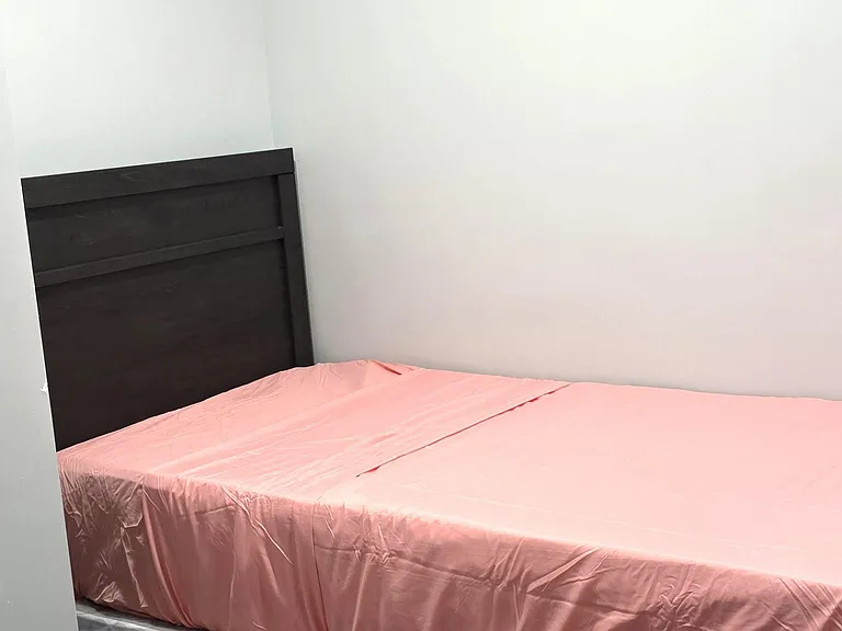 Furnished bedroom featuring a platform bed and carpeted flooring, offering a simple layout with space to unwind.