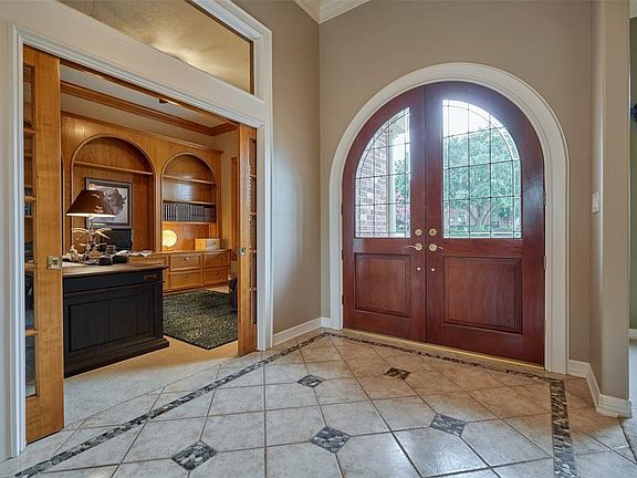 Study is located just off the entryway through double pocket doors. Notice the unique detail of the tiled entry and the transom window above the study doors.