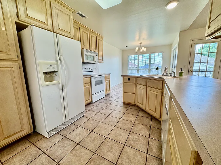 Generous cabinet and counter space with a second angle showing the full kitchen layout