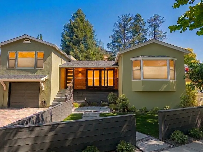 Front Exterior. Lights on, with light filtering privacy shades on street side.