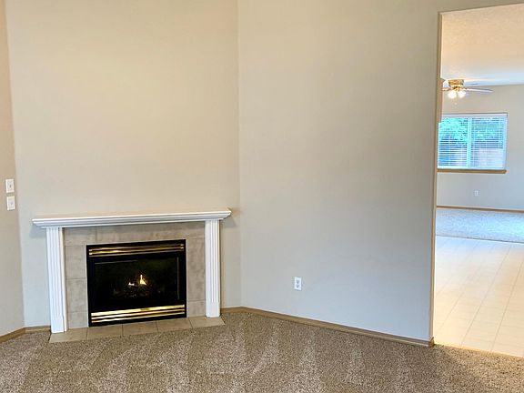 Vaulted Living Room with Gas Log Fireplace and Ceiling Fan.