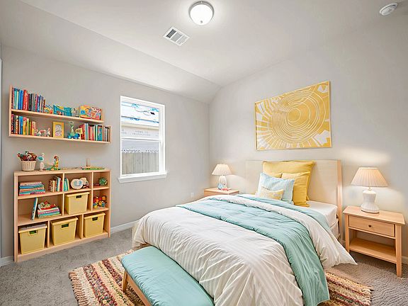 Cozy second bedroom with a walk-in closet, plush carpet, and a bright window.