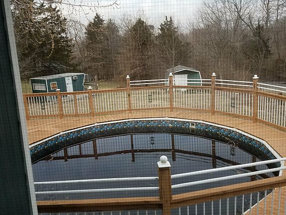 view of pool and 2 storage sheds in back of yard